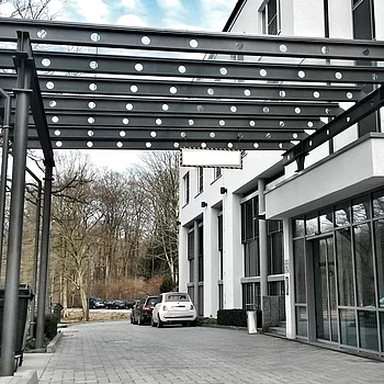 Überdachung aus Stahl und Glas mit runden Lichtern