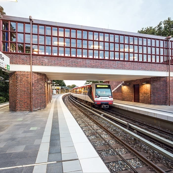 Eine Eisenbahnbrücke mit rotem Backstein und großen Fenstern.