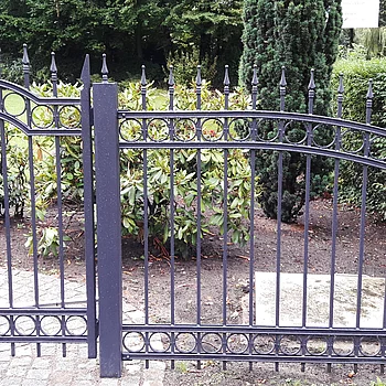 Schmiedeeiserne Gartenpforte mit geschwungenem Oberteil und runden Ornamenten