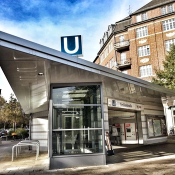 U-Bahn-Station mit modernem, schrägem Dach und Glasfassade.