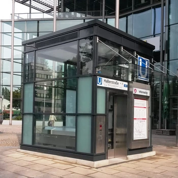 Moderne U-Bahn-Station mit Glaswänden und schwarzem Dach.