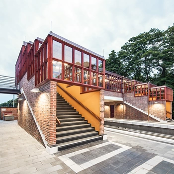 Treppenaufgang zu einer Brücke aus Stahl und Ziegel, mit großen Fenstern und...