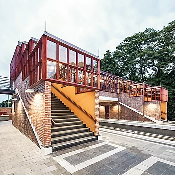 Treppenaufgang zu einer Brücke aus Stahl und Ziegel, mit großen Fenstern und...