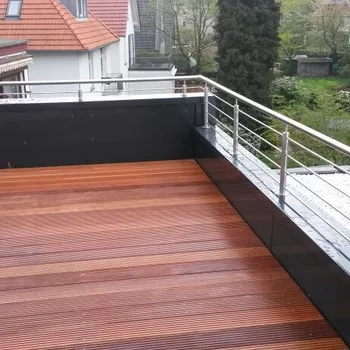 Holzterrasse mit horizontalen Dielen in verschiedenen Brauntönen, umgeben von einem...