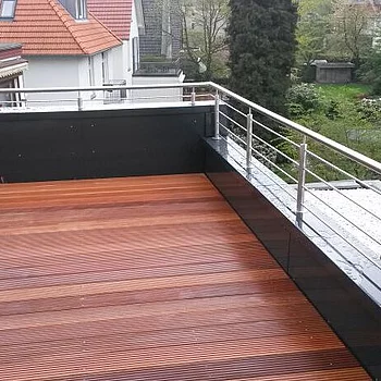 Holzterrasse mit horizontalen Dielen in verschiedenen Brauntönen, umgeben von einem...